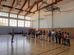 Učenici 4.c i korisnici stoje u vrsti u sportskoj dvorani